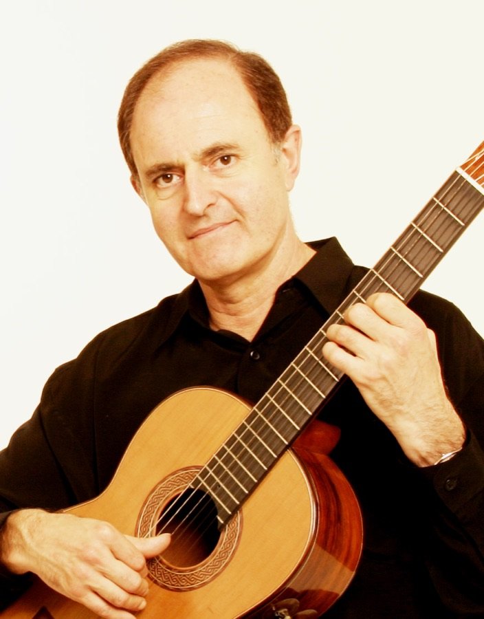 Close-up of Julian Byzantine playing guitar, against a white background
