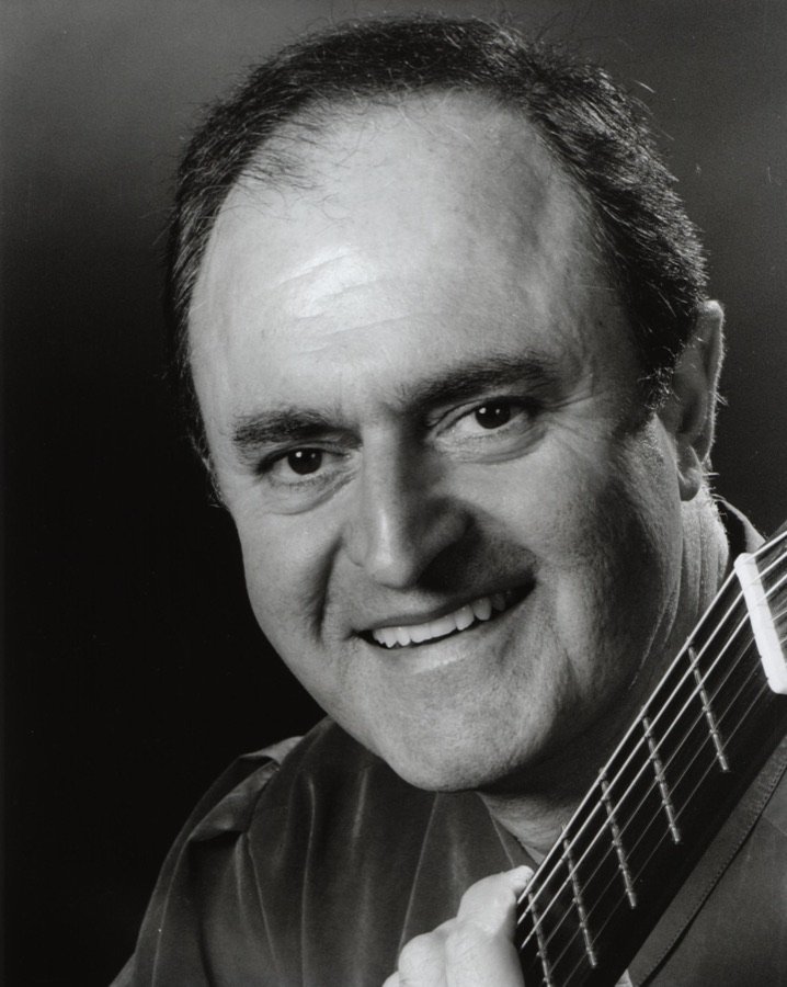 Black and white portrait of Julian Byzantine smiling, with his guitar